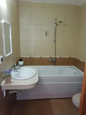 a bathroom with a tub and a sink and a toilet at Evrika home 4 in Pamporovo