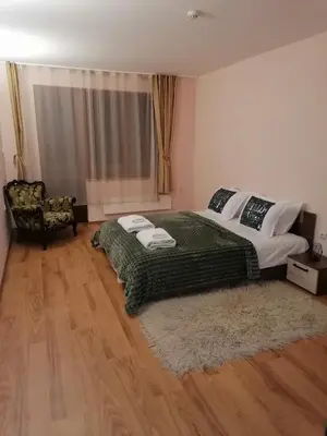 a bedroom with a large bed and a chair at Evrika home 4 in Pamporovo