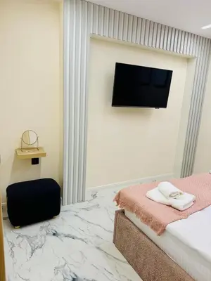 a bedroom with a bed and a flat screen tv at luxuri suite ''dezodava'' in Sandanski