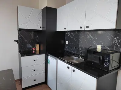 a kitchen with white cabinets and a sink and a microwave at Mountain Ski & SPA apartment in Pamporovo