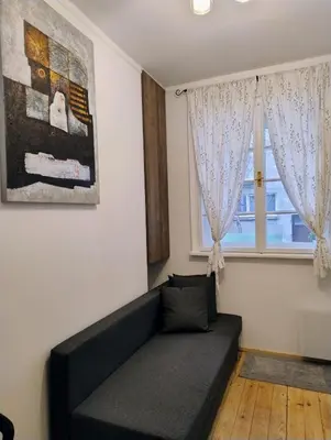 a living room with a couch and a window at Tiny studio in top center in Sofia