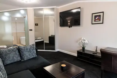 a living room with a couch and a table at Семеен Хотел Олимп in Sopot