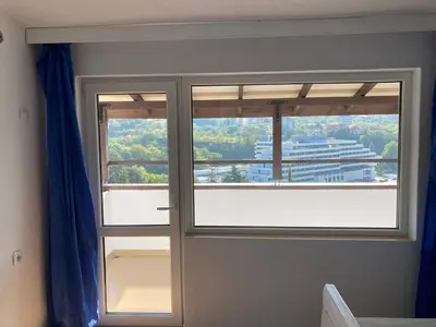 a room with two windows with blue curtains at Apartment Park View in Sandanski