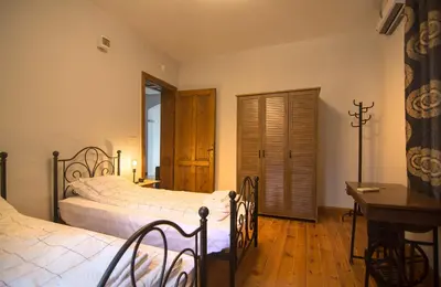 a bedroom with two beds and a table and a desk at Tatyana City garden in Plovdiv