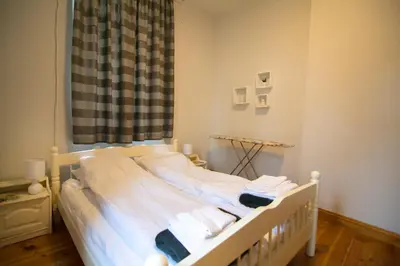 a bedroom with a bed with white sheets and a window at Tatyana City garden in Plovdiv
