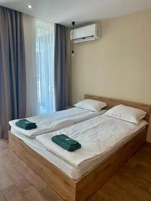 a bedroom with a bed with two green towels on it at Music Flats in Sofia