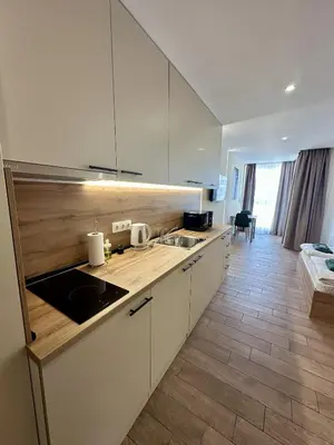 a kitchen with white cabinets and a counter top at Music Flats in Sofia
