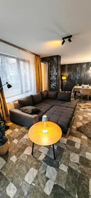 a living room with a couch and a table at Modern apartment with terrace in Chepelare