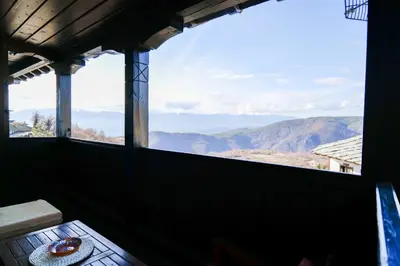 a room with a window with a view of mountains at Трите къщи in Leshten