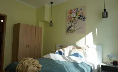 a bedroom with a bed and a painting on the wall at S íRMA Apartment - Next to the Old Cathedral in Sofia