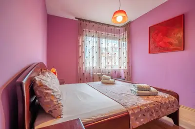 a bedroom with a bed with purple walls and a window at Central Sofia Retreat in Sofia