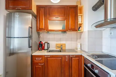 a kitchen with wooden cabinets and a stainless steel refrigerator at Central Sofia Retreat in Sofia