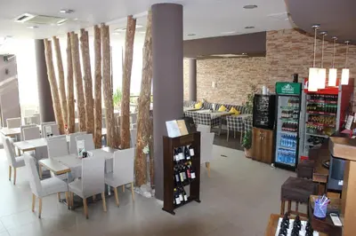 a restaurant with white chairs and tables and a store at Apartment for guests in Bansko
