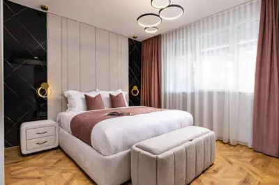 a bedroom with a large bed and a chair at Happy People 2 BD, Central Plovdiv by Flat Mаnager in Plovdiv