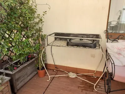a grill sitting in the corner of a garden at Princess Apartment in Sandanski