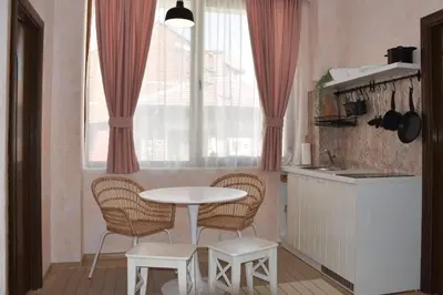 a kitchen with a table and chairs and a window at Princess Apartment in Sandanski