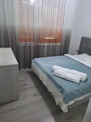 a bedroom with a bed with two towels on it at Удобство - 2 in Petrich