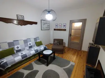 a living room with a couch and a table at просторен и уютен двустаен в Долен Лозенец - кварталът на артистите in Sofia