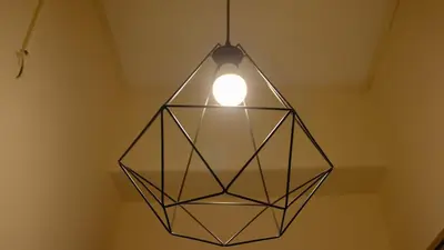 a glass pendant light hanging from a ceiling at просторен и уютен двустаен в Долен Лозенец - кварталът на артистите in Sofia
