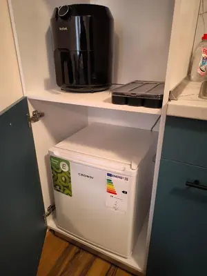 a small refrigerator in a kitchen with a coffee maker at NiSimo Apartment Grand Resort Pamporovo in Pamporovo