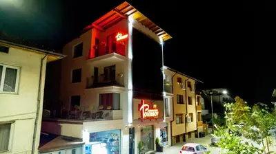 a building with a neon sign on the side of it at Apartments Polejanov in Razlog