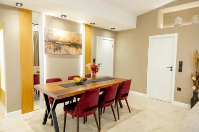 a dining room with a wooden table and red chairs at Apartments Polejanov in Razlog