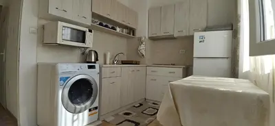 a kitchen with a washing machine and a refrigerator at Апартамент Калоян in Banya