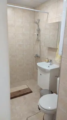 a bathroom with a shower and a toilet and a sink at Апартамент Калоян in Banya