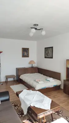 a bedroom with two beds and a table in it at Апартамент Калоян in Banya