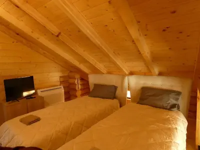two beds in a room with wooden ceilings at Стилни и Луксозни Вили за разпускане in Malo Buchino