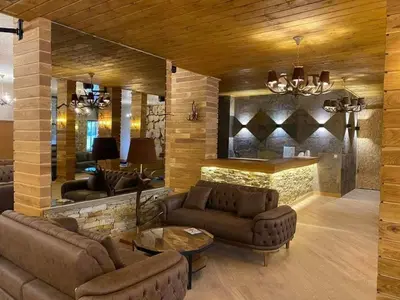 a living room with couches and a stone wall at Grand Studio A1 in Pamporovo