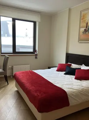 a bedroom with a large bed with red pillows at Beauty&Travel Apartment Borovets in Borovets