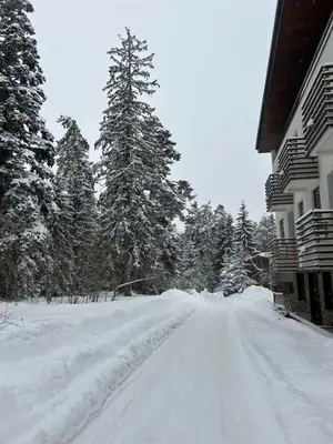 a road covered in snow next to a house at Beauty&Travel Apartment Borovets in Borovets