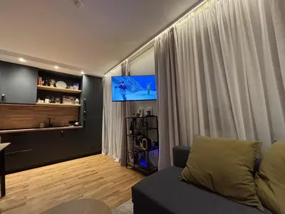 a living room with a couch and a flat screen tv at Ski-in Flat Next to Ski Road at Mountain View in Bansko