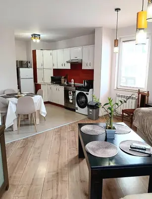 a large living room with a table and a kitchen at Double to bul Tsar Boris 3 in Sofia