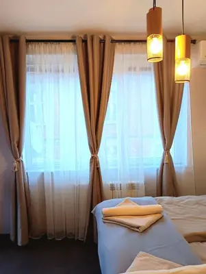 a bedroom with a bed and a window with curtains at Double to bul Tsar Boris 3 in Sofia