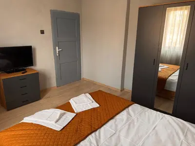 a bedroom with two towels on a bed and a television at Апартамент Лилия Сандански in Sandanski