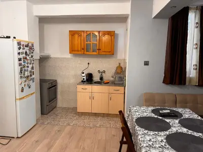 a kitchen with wooden cabinets and a white refrigerator at Апартамент Лилия Сандански in Sandanski