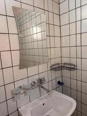a white bathroom with a sink and a mirror at Апартамент Лилия Сандански in Sandanski