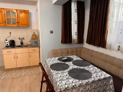 a small kitchen with a table and a couch at Апартамент Лилия Сандански in Sandanski