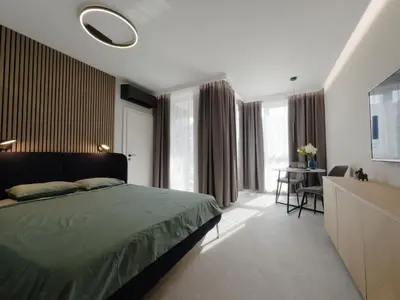 a bedroom with a green bed and a table and chairs at Eleve Residences Sofia in Sofia