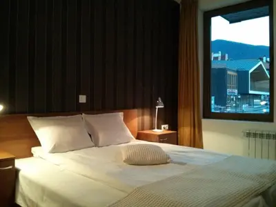a bedroom with a large white bed with a window at Granat next to Ski Lift by BookVillaBG in Bansko