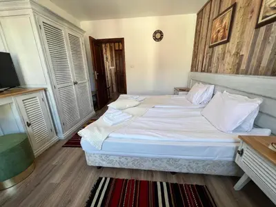 a bedroom with a large bed with white sheets at Granat next to Ski Lift by BookVillaBG in Bansko
