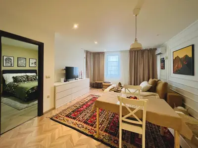 a living room with a table and a bedroom at Lagom Apartment - Next to the Gondola in Bansko