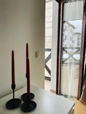 two red candles sitting on top of a table at Lagom Apartment - Next to the Gondola in Bansko