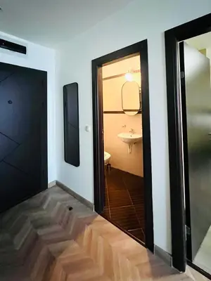 a bathroom with a door and a sink in a room at Lagom Apartment - Next to the Gondola in Bansko