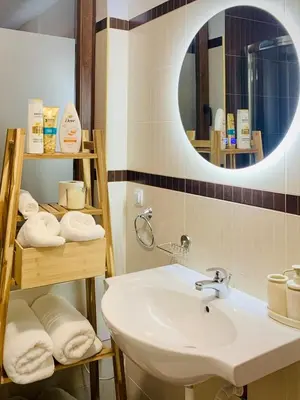 a bathroom with a sink and a mirror and towels at Lagom Apartment - Next to the Gondola in Bansko