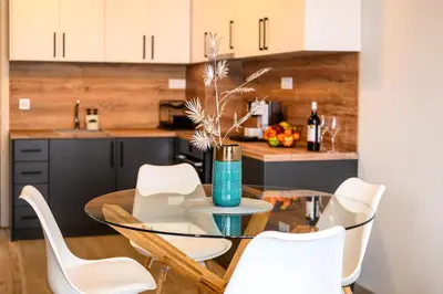a dining room with a glass table and white chairs at DreamAparts in Velingrad