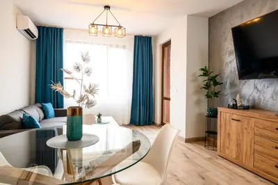 a living room with a glass table and a couch at DreamAparts in Velingrad
