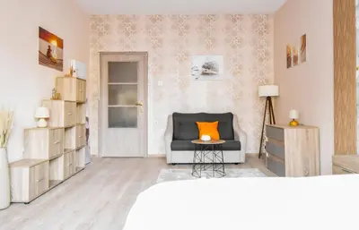 a living room with a chair with an orange pillow on it at Orchidea City Centre 1BDR by Flat Mаnager in Sofia